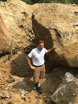 Grenco Septic Systems and Excavation removes such large boulders that they dwarf owner and founder Scott Grenon.